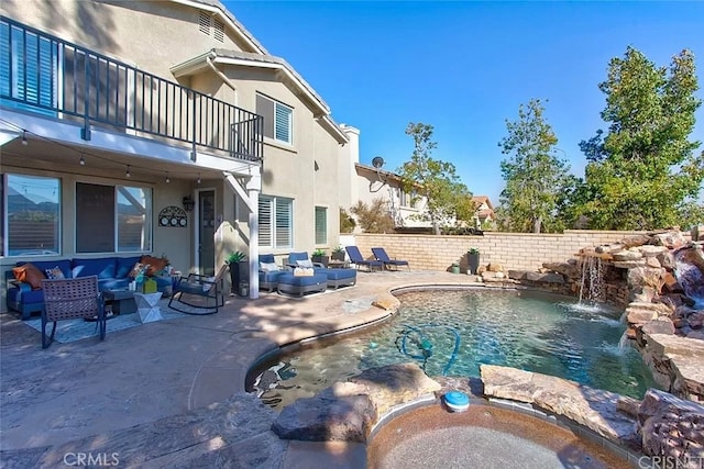 view of pool with pool water feature, an outdoor living space, and a patio area