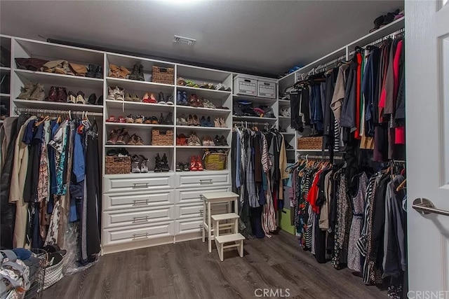 spacious closet featuring dark hardwood / wood-style flooring