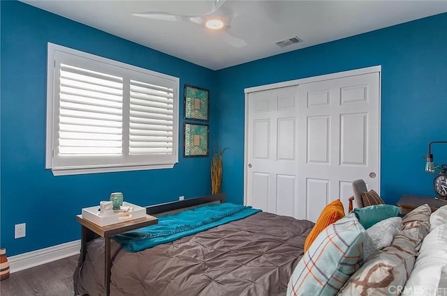 bedroom featuring ceiling fan, a closet, and dark hardwood / wood-style flooring