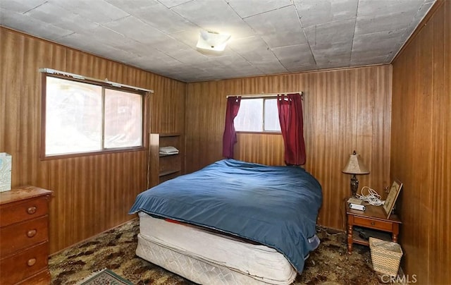 carpeted bedroom featuring wooden walls