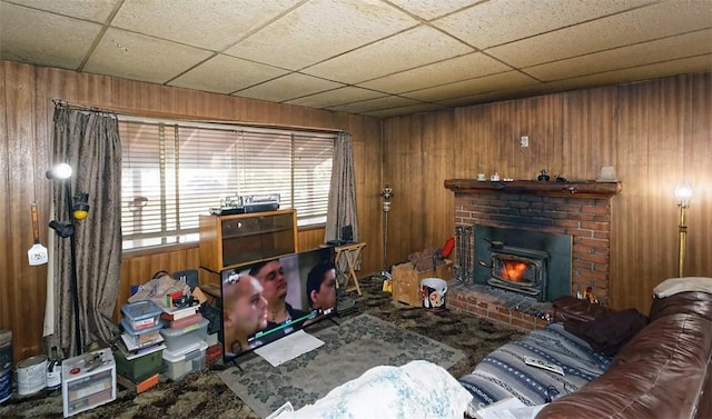 living room with a wood stove and wooden walls