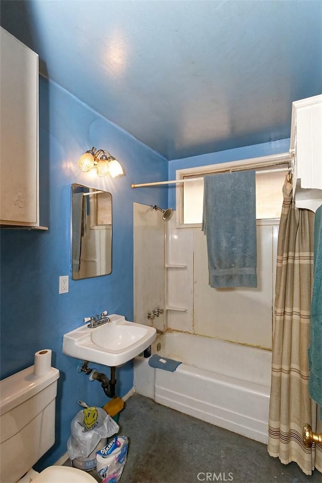 full bathroom featuring toilet, shower / bath combo with shower curtain, and sink