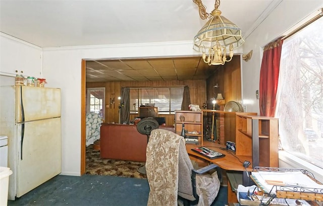 carpeted office space with crown molding, wooden walls, and a notable chandelier