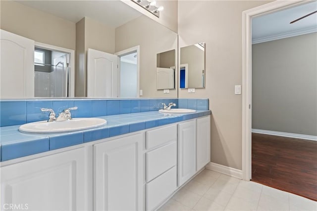 bathroom with tile patterned flooring, vanity, and ornamental molding