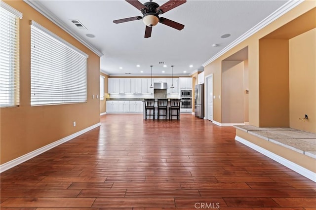 unfurnished living room with dark wood-type flooring, ceiling fan, and ornamental molding