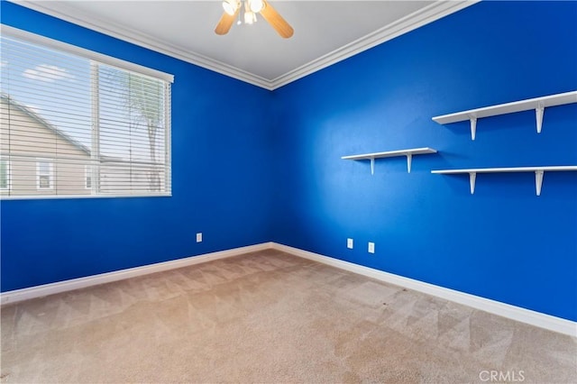 empty room with ornamental molding, carpet floors, and ceiling fan