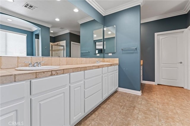 bathroom with tile patterned floors, ornamental molding, a shower with door, and vanity