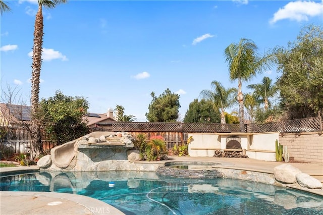 view of pool featuring an in ground hot tub and a water slide