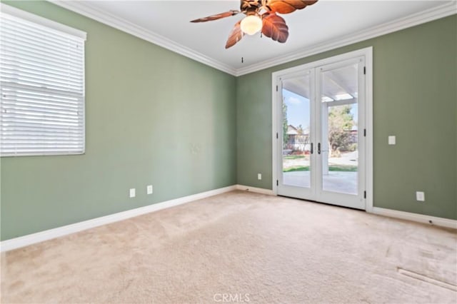 carpeted spare room featuring crown molding, french doors, and ceiling fan