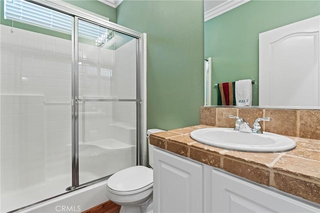 bathroom featuring vanity, toilet, and an enclosed shower