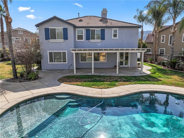 rear view of property with a lawn and a patio