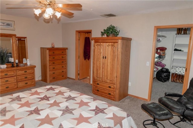 carpeted bedroom with a closet, a walk in closet, and ceiling fan