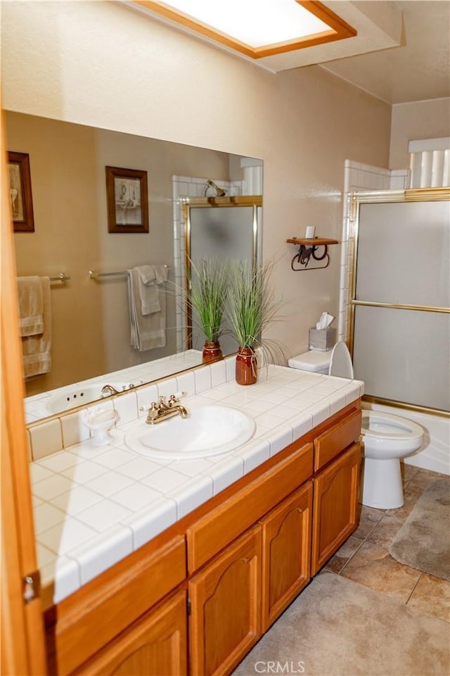 full bathroom with enclosed tub / shower combo, toilet, and vanity