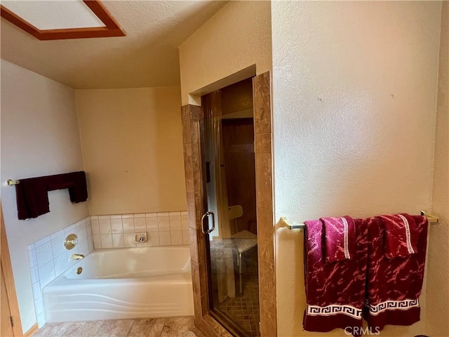 bathroom with a textured ceiling, tile patterned floors, and independent shower and bath