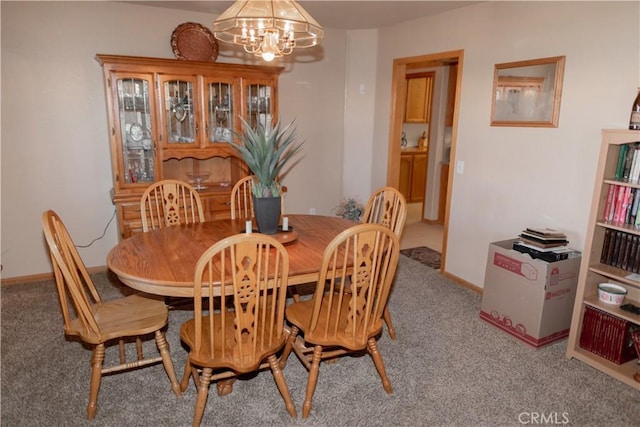 carpeted dining space with an inviting chandelier