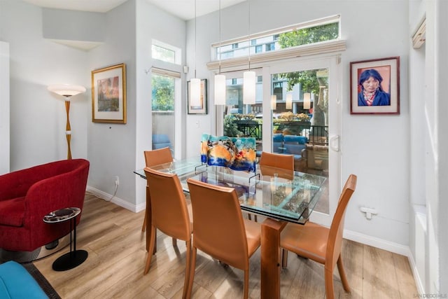 dining room featuring a high ceiling and light hardwood / wood-style floors