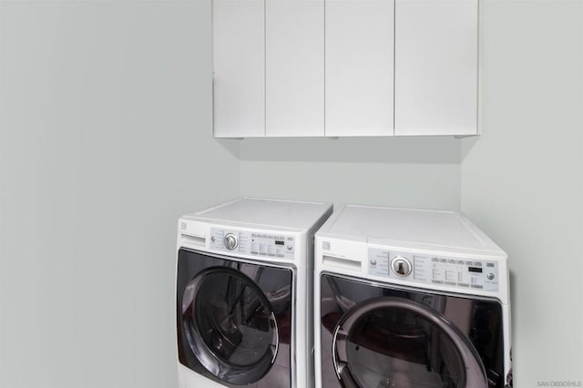 washroom featuring cabinets and separate washer and dryer