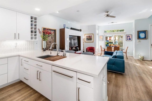 kitchen with kitchen peninsula, sink, and white cabinets