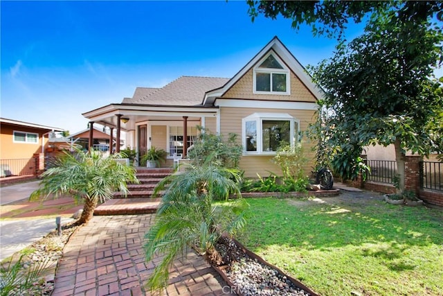 view of front of property featuring a front yard and covered porch