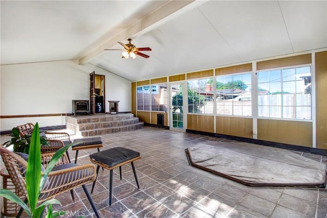 sunroom with vaulted ceiling with beams, ceiling fan, and a wood stove