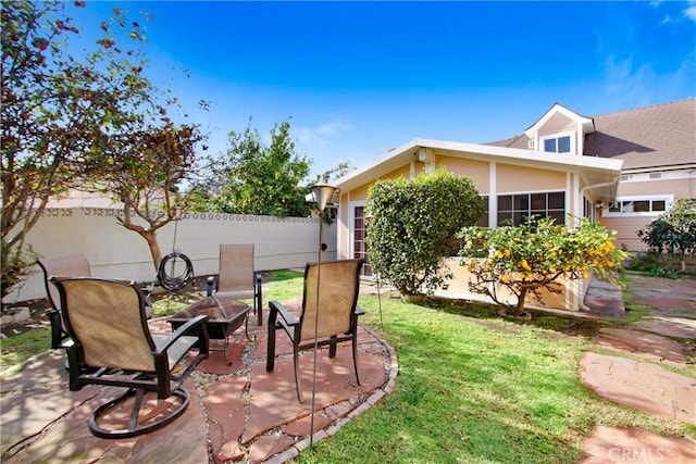 view of yard featuring a fire pit, a patio area, and fence