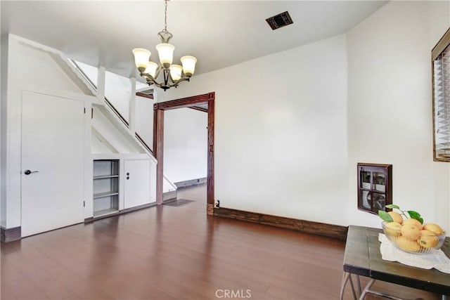 unfurnished dining area with dark hardwood / wood-style floors and a chandelier