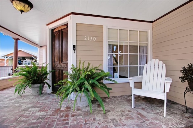 view of exterior entry featuring covered porch