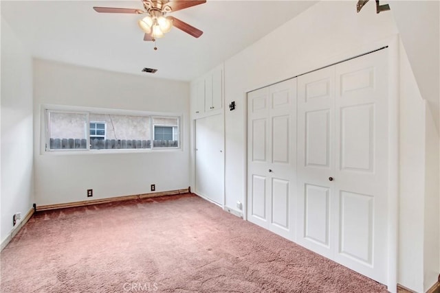 unfurnished bedroom with ceiling fan, visible vents, baseboards, a closet, and carpet