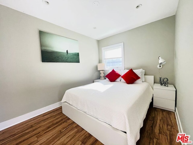 bedroom with dark hardwood / wood-style floors