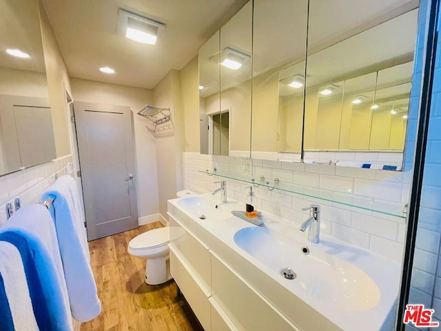 bathroom featuring toilet, vanity, decorative backsplash, and hardwood / wood-style flooring