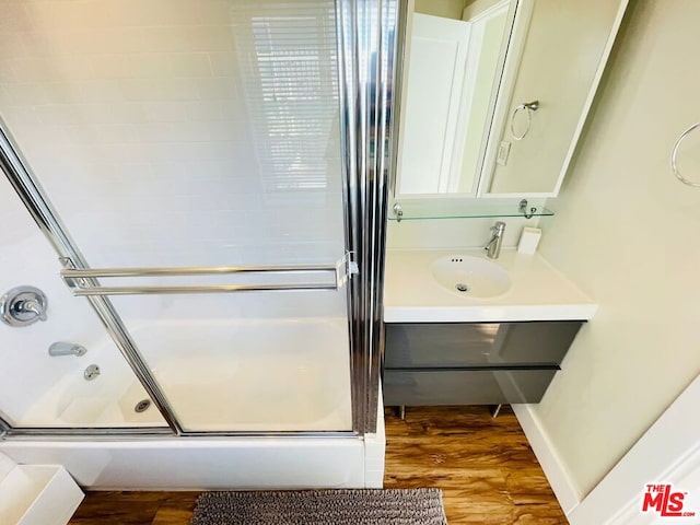 bathroom with hardwood / wood-style floors, walk in shower, and vanity