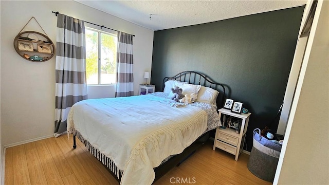 bedroom featuring light wood-type flooring and a textured ceiling