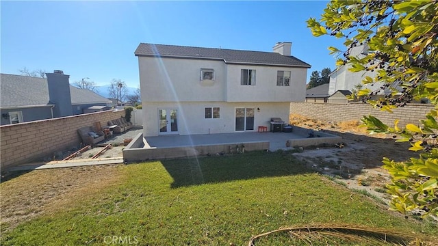 back of house featuring a lawn, french doors, and a patio