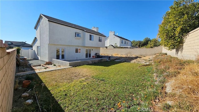 back of property featuring a patio area and a yard