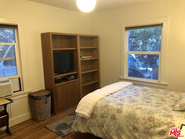 bedroom featuring cooling unit and dark hardwood / wood-style flooring