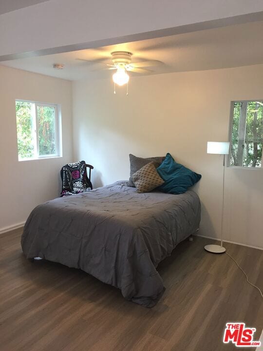 bedroom with ceiling fan and dark hardwood / wood-style flooring