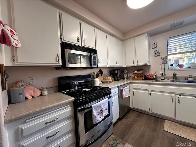 kitchen with white cabinets, dark hardwood / wood-style floors, sink, and stainless steel appliances