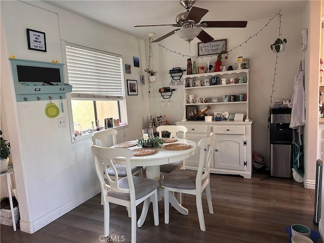 dining area with dark wood-type flooring and ceiling fan