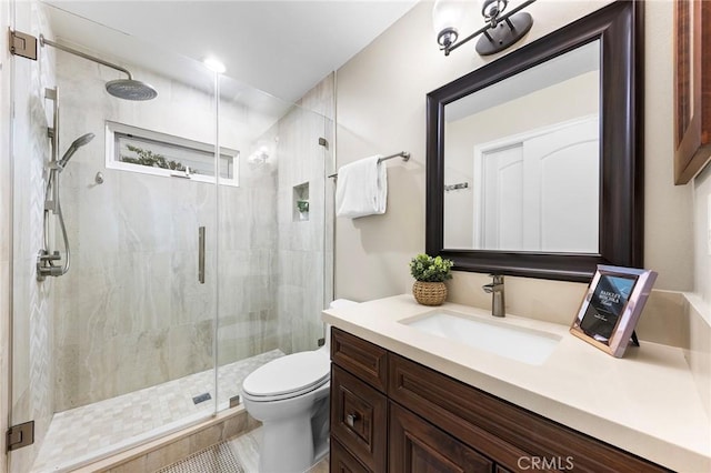 bathroom featuring toilet, vanity, tile patterned flooring, and an enclosed shower