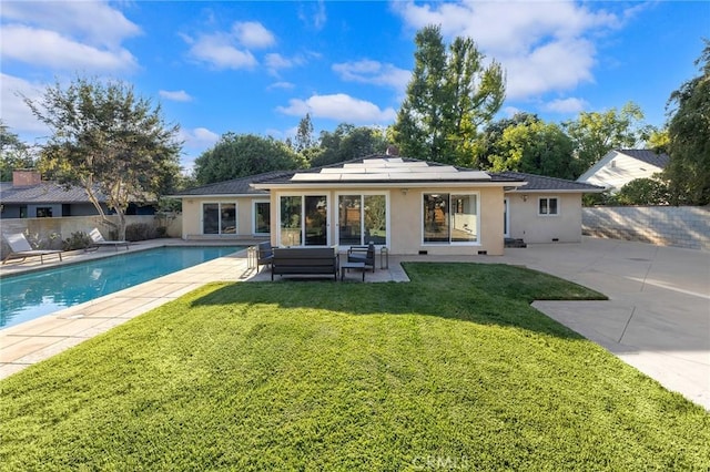 rear view of house featuring a patio area, a lawn, outdoor lounge area, and solar panels