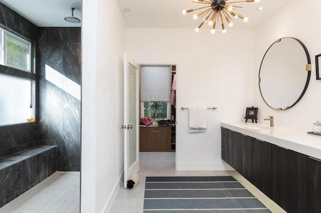 bathroom with concrete floors, a shower, vanity, and a notable chandelier