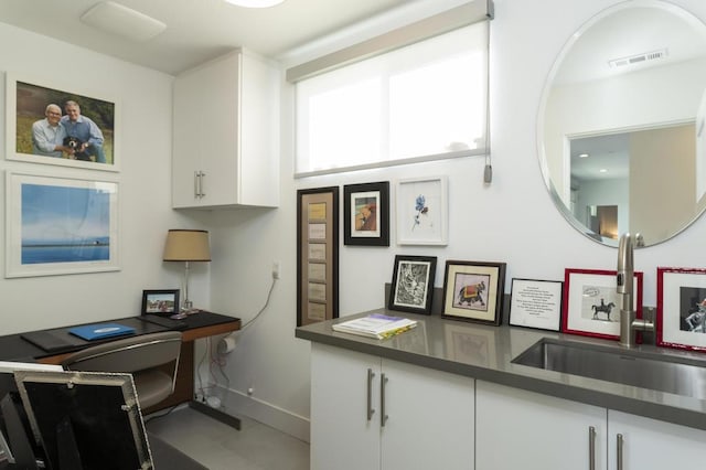 interior space with white cabinets and sink