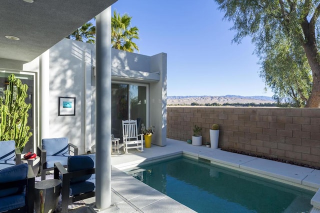 view of pool featuring a mountain view and a patio