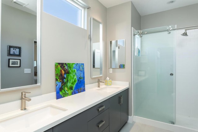 bathroom featuring a shower with shower door and vanity