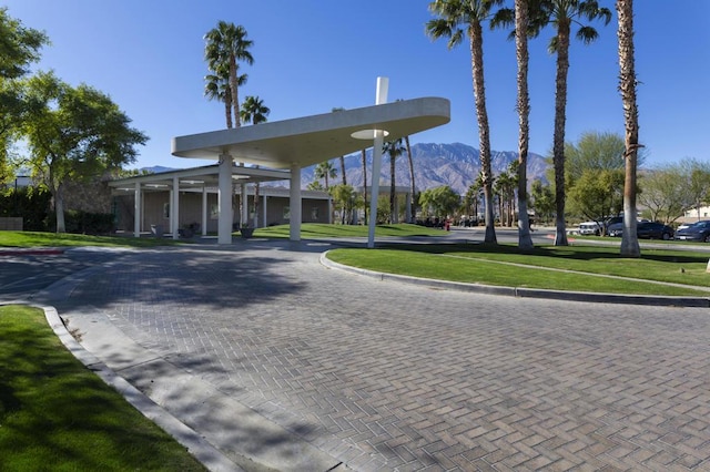 view of property's community featuring a lawn and a mountain view