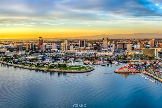 aerial view at dusk featuring a water view