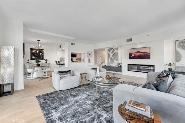 living room featuring an inviting chandelier and light hardwood / wood-style flooring