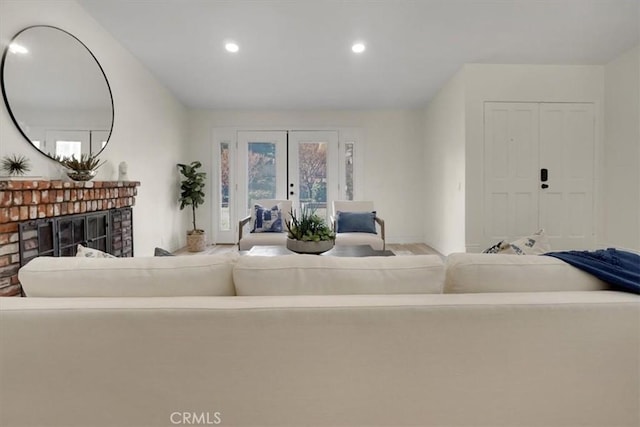 living room with a brick fireplace and french doors