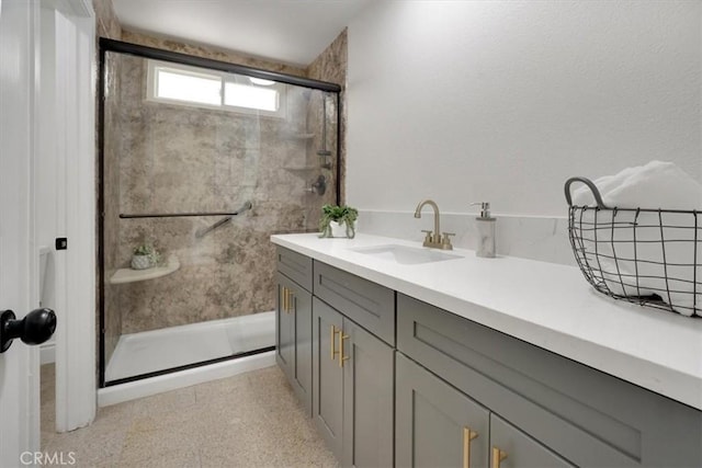 bathroom featuring a shower with door and vanity