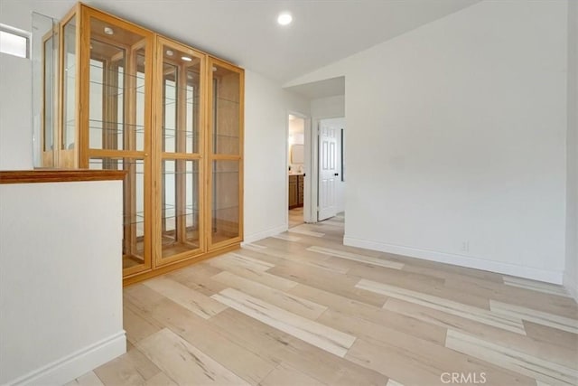 empty room featuring lofted ceiling and light hardwood / wood-style floors